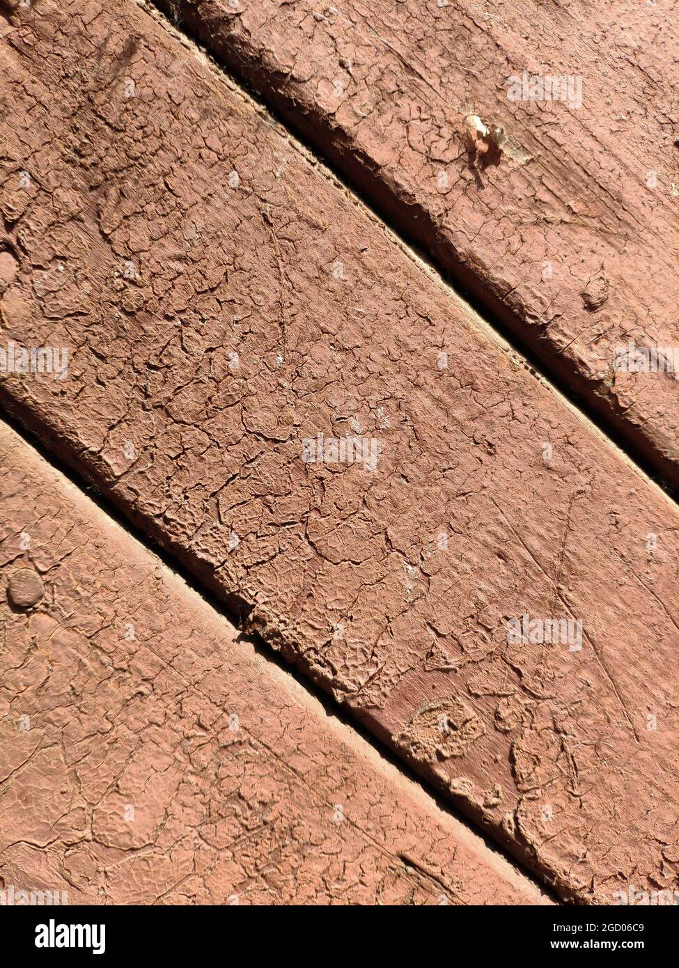 Bois texturé dans la peinture rose avec des fissures de l'ancien âge Banque D'Images