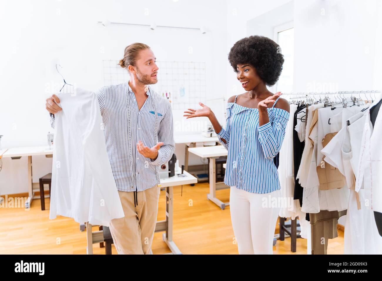 Équipe multiethnique de créateurs de mode travaillant dans un atelier de démarrage de vêtements - groupe multiracial de stylistes, de designers sur mesure et de couturiers travaillant dans Banque D'Images