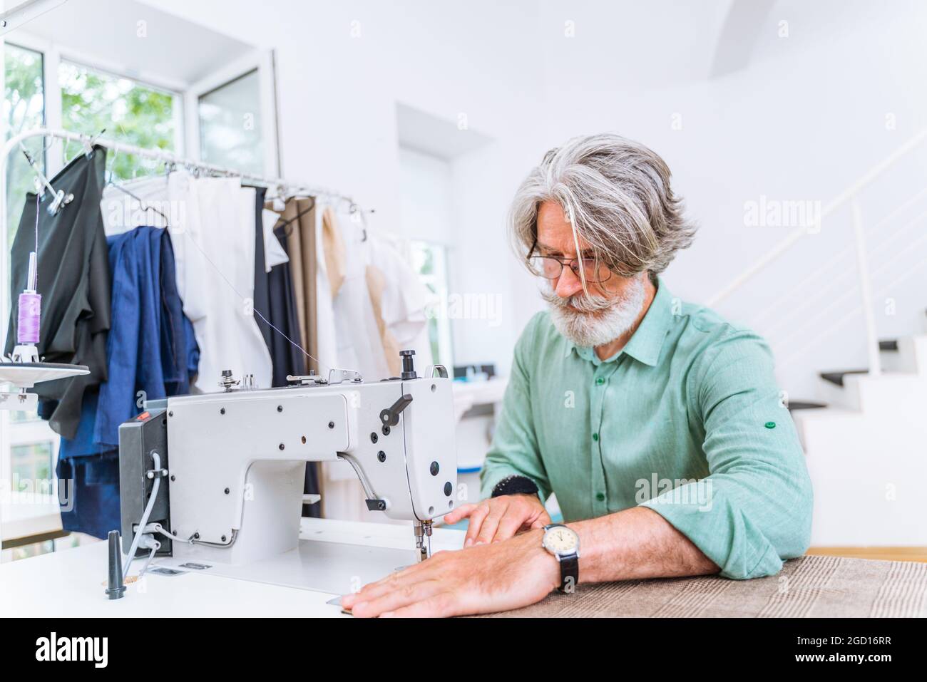 Équipe multiethnique de créateurs de mode travaillant dans un atelier de démarrage de vêtements - groupe multiracial de stylistes, de designers sur mesure et de couturier Banque D'Images