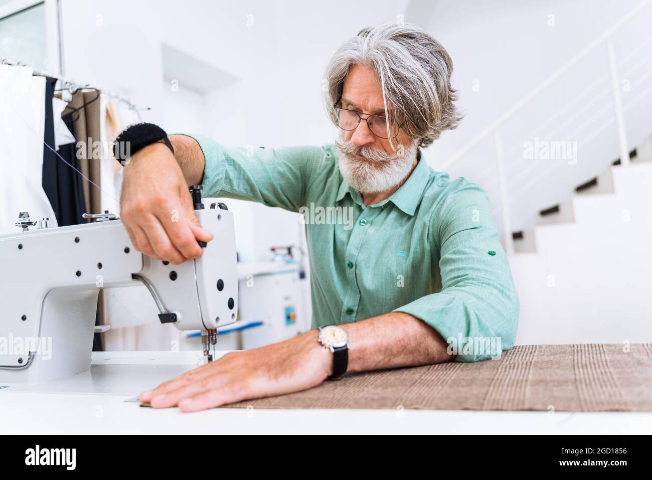 Équipe multiethnique de créateurs de mode travaillant dans un atelier de démarrage de vêtements - groupe multiracial de stylistes, de designers sur mesure et de couturier Banque D'Images