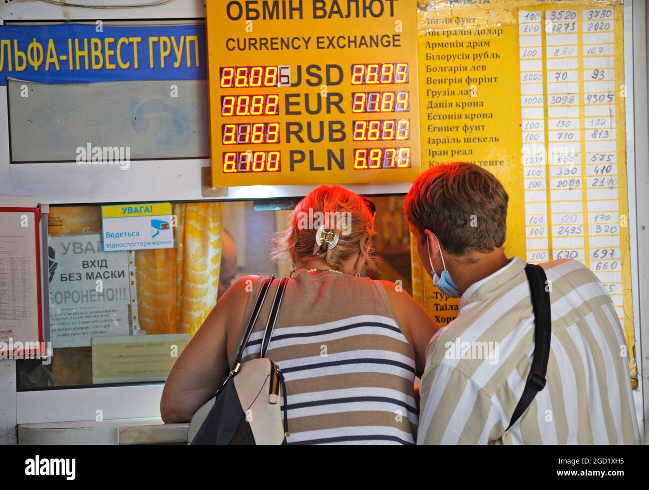 Femme et jeune garçon regardant le comptoir du bureau de change de devises,  la plaque de change de devises est au-dessus de la tête. 7 août 2021. Kiev,  Ukraine Photo Stock - Alamy