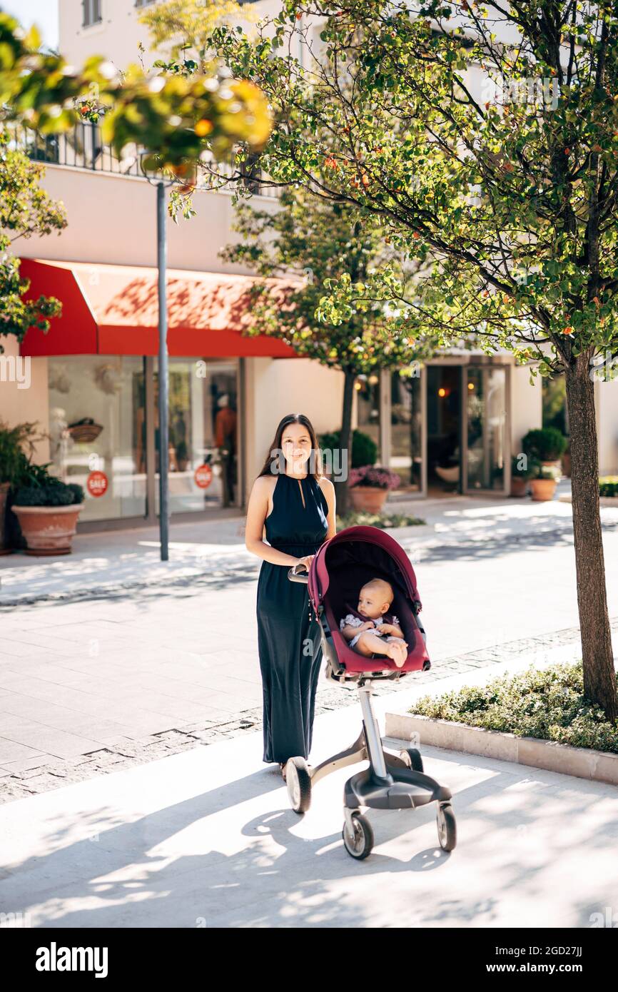 Maman avec bébé dans une poussette dans une rue de ville Photo Stock - Alamy