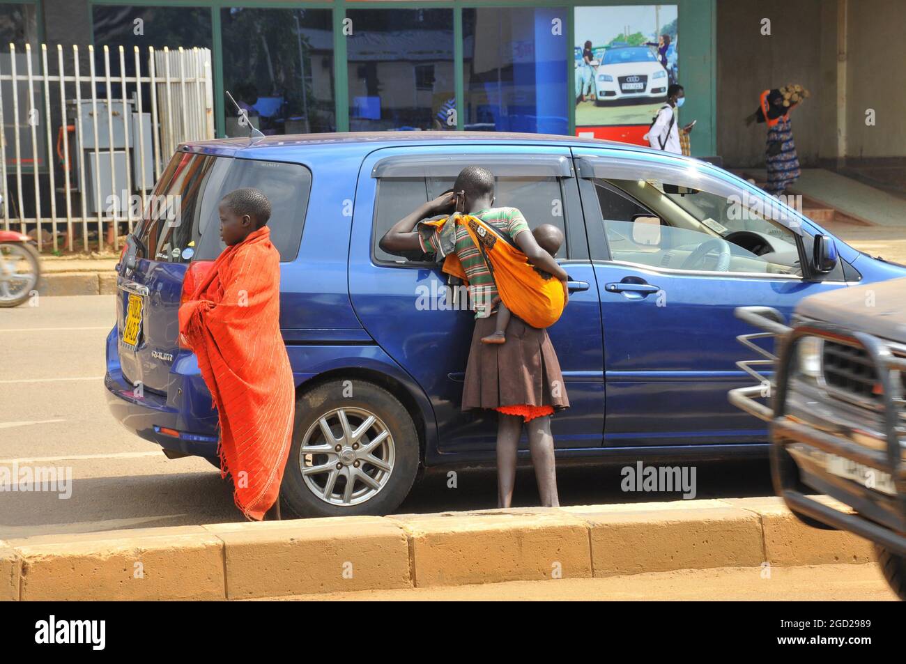 Des enfants des rues mendiaient des véhicules dans la ville de Kampala. Les familles envoient normalement des enfants dans les rues pour mendier comme moyen de survivre. Ouganda. Banque D'Images