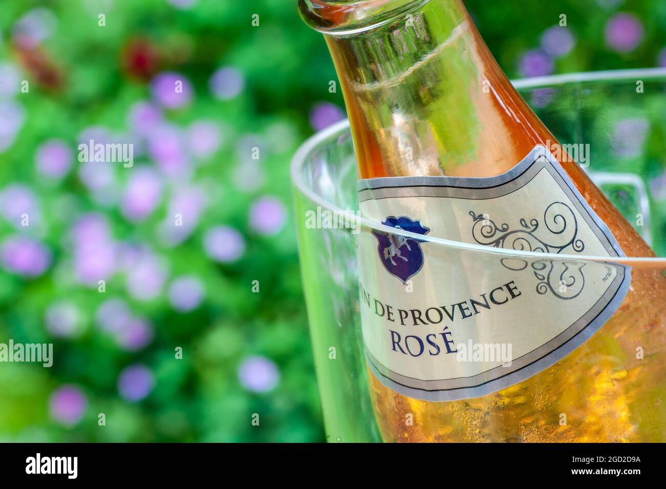 Bouteille de vin de French Rosé des Côtes de Provence dans un refroidisseur à vin sur une table de pique-nique en plein air avec des fleurs au coucher du soleil Banque D'Images