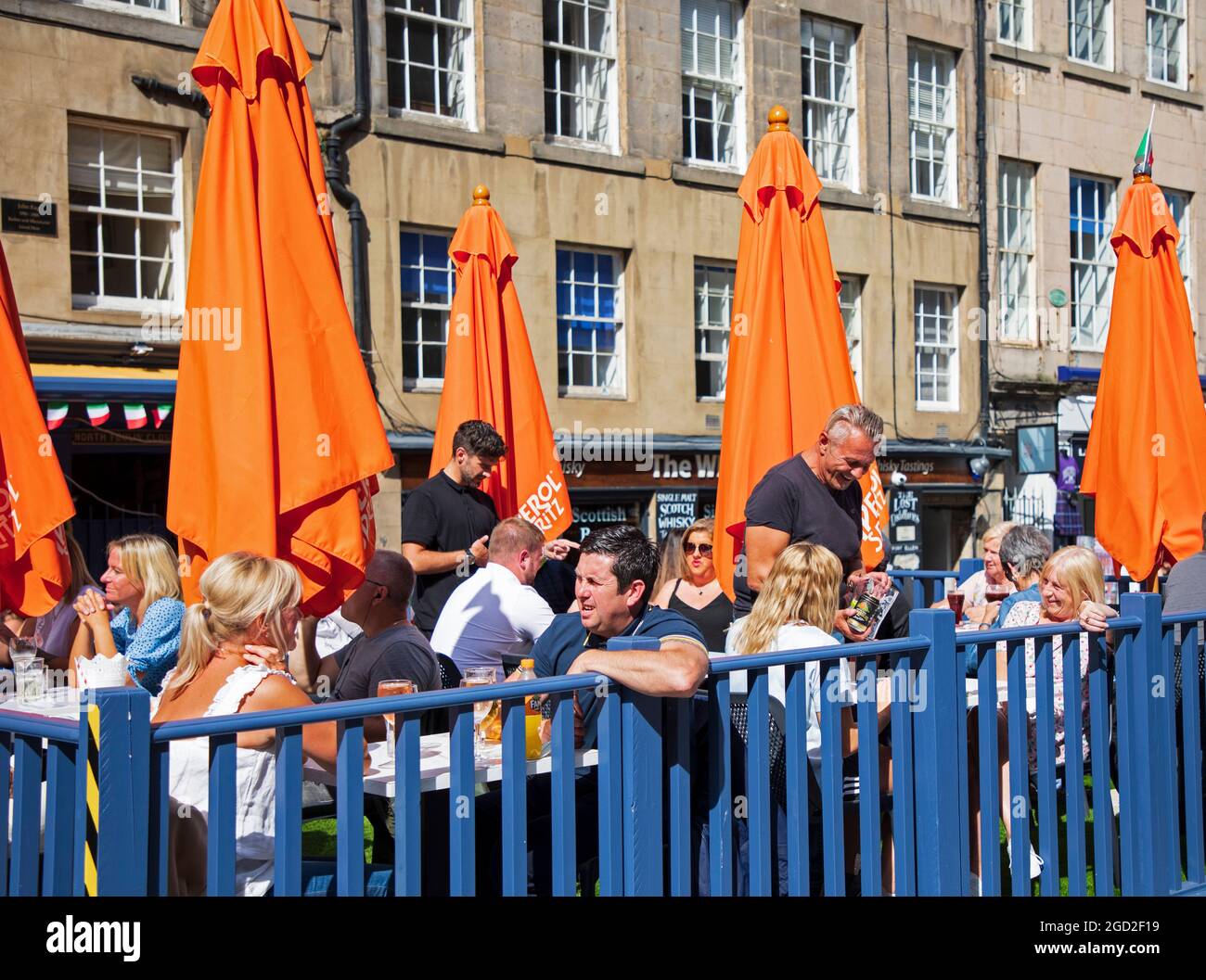 Royal Mile, Édimbourg, Écosse, Royaume-Uni. 10e Agoust 2021. Les foules retournent à High Street pour ce premier lundi ensoleillé du Fringe Festival, qui a donné aux artistes un public plus large qu'au cours du week-end. En photo : la Trattoria de Gordon est occupée par les clients dans les zones de sièges extérieurs, Gordon sert les clients. Crédit : Arch White/Alamy Live News Banque D'Images