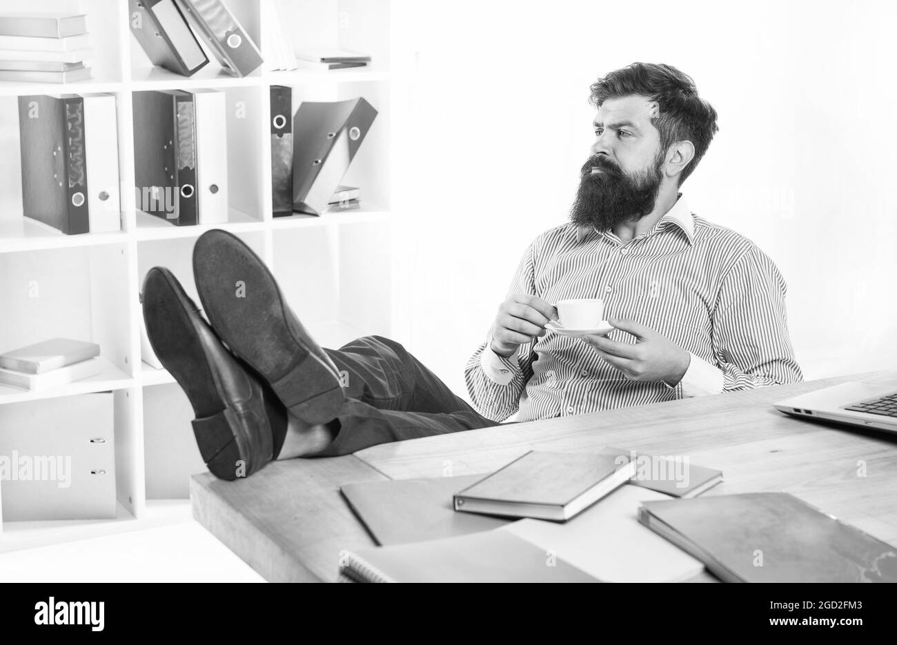 Un homme d'affaires attaché se détendre sur le lieu de travail en buvant une tasse chaude de thé ou de café dans le bureau moderne, énergie Banque D'Images