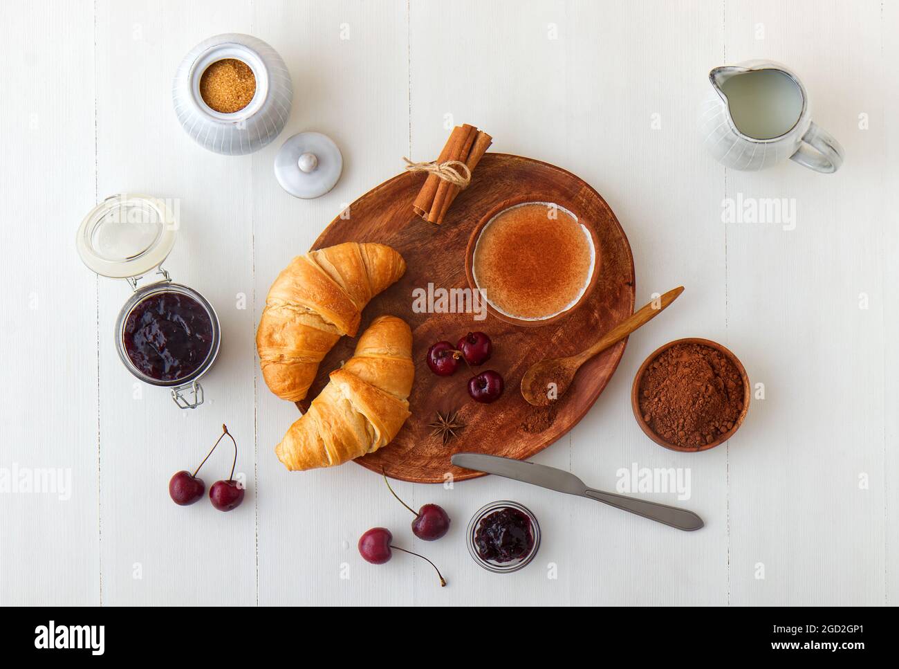 Plats sains savoureux, petit déjeuner, brunch ou juste dessert. Croissants frais avec confiture de la dernière récolte de cerises et chocolat chaud. Table en bois blanc Banque D'Images