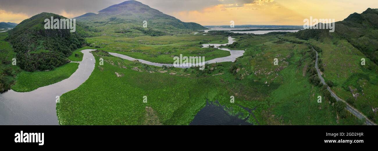 Le soleil qui brille à travers les nuages au loin avec la rivière Owengarriff dans le parc national de Killarney dans le comté de Kerry Ireland en premier plan Banque D'Images