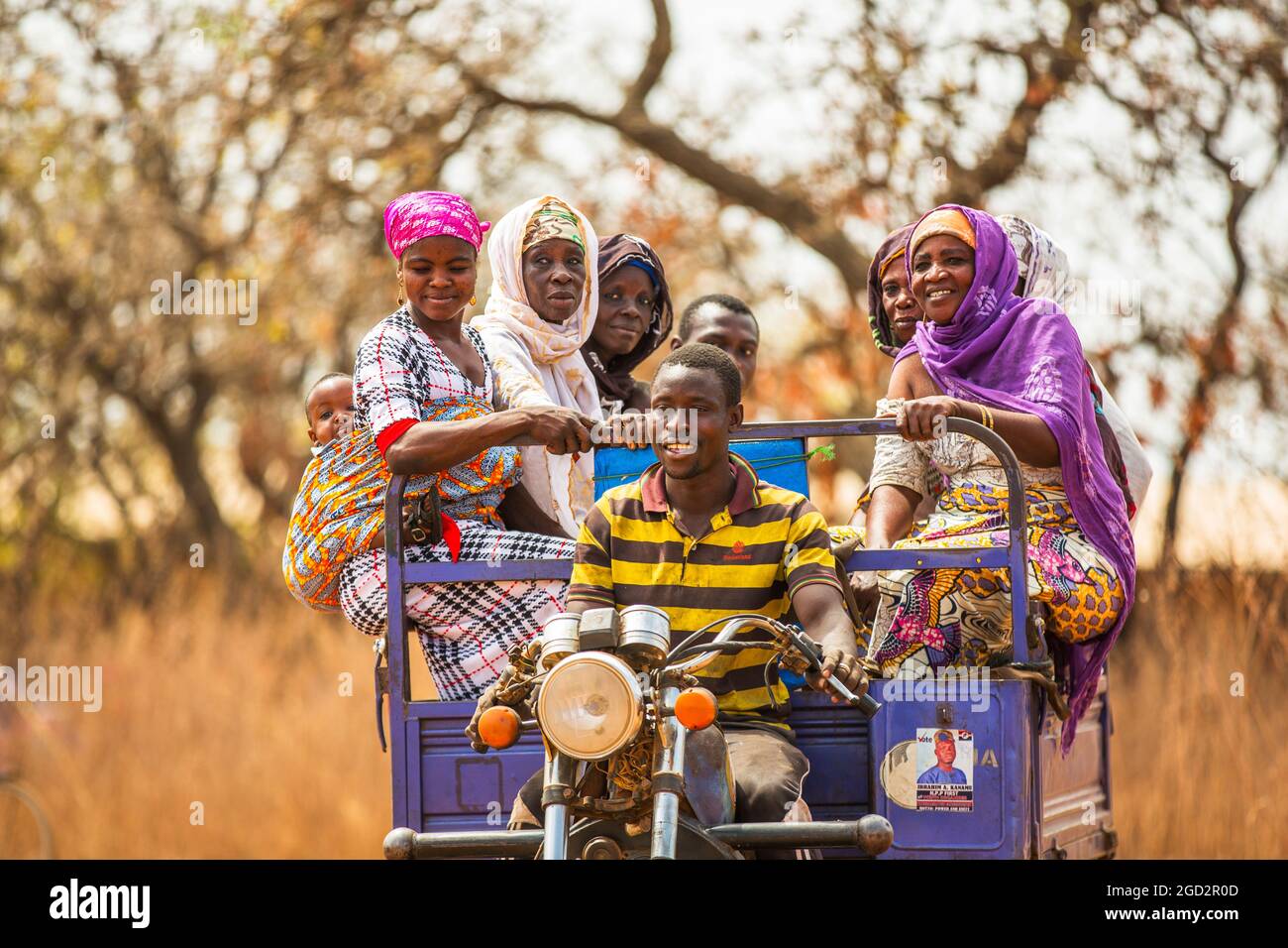 Un homme conduisant une moto chariot ferries ouest Afrique village femmes ca. 21 février 2018 Banque D'Images