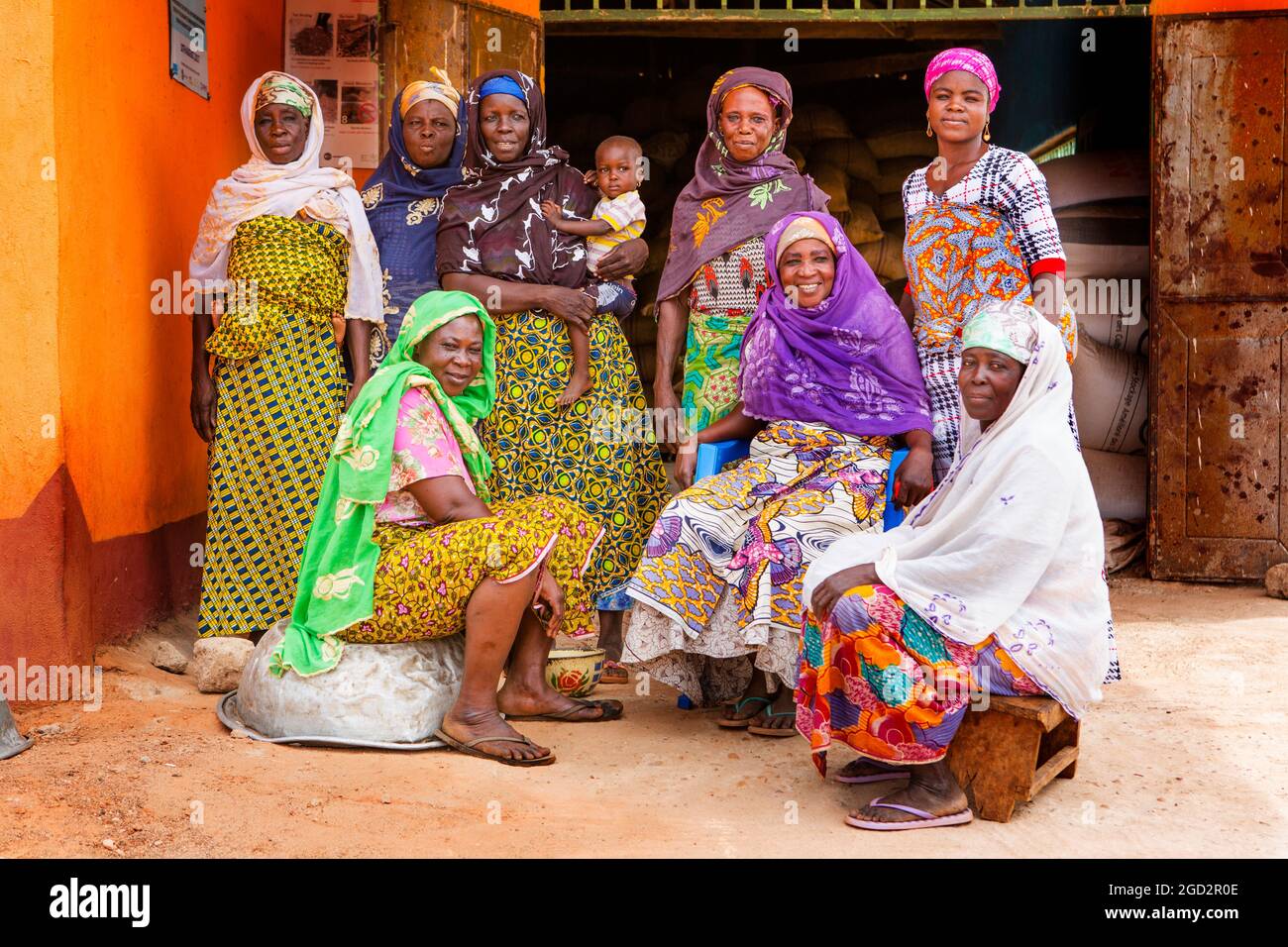 Ces femmes d'Afrique de l'Ouest portant la robe traditionnelle colorée pose pour la caméra dans leur village ca. 21 février 2018 Banque D'Images