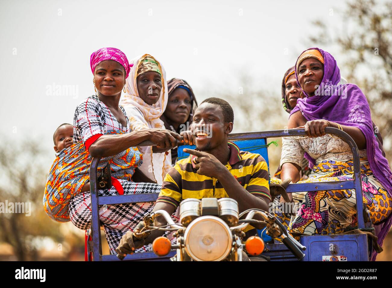 Un homme conduisant une moto chariot ferries ouest Afrique village femmes ca. 21 février 2018 Banque D'Images