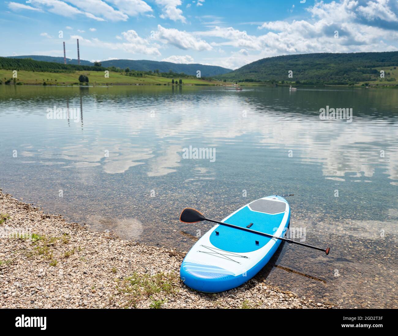 Stand-up moderne abandonné paddleboard sur le rivage de gravier. Calme et silencieux au bord du lac Banque D'Images