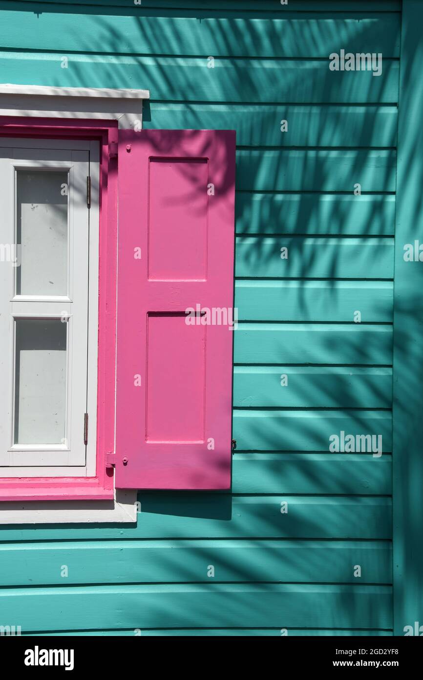 Bâtiment et fenêtre turquoise aux couleurs des Caraïbes avec volets roses Banque D'Images