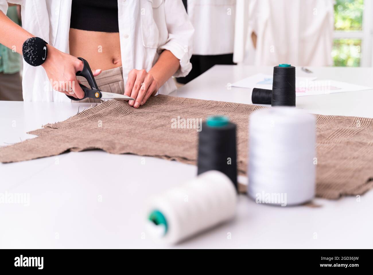 Équipe multiethnique de créateurs de mode travaillant dans un atelier de démarrage de vêtements - groupe multiracial de stylistes, de designers sur mesure et de couturier Banque D'Images