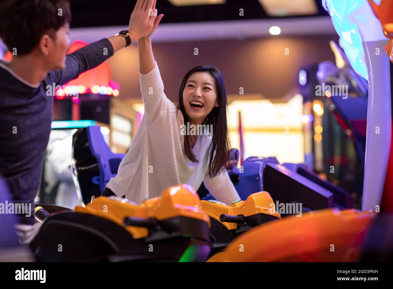Un jeune couple heureux jouant dans une salle d'arcade Banque D'Images