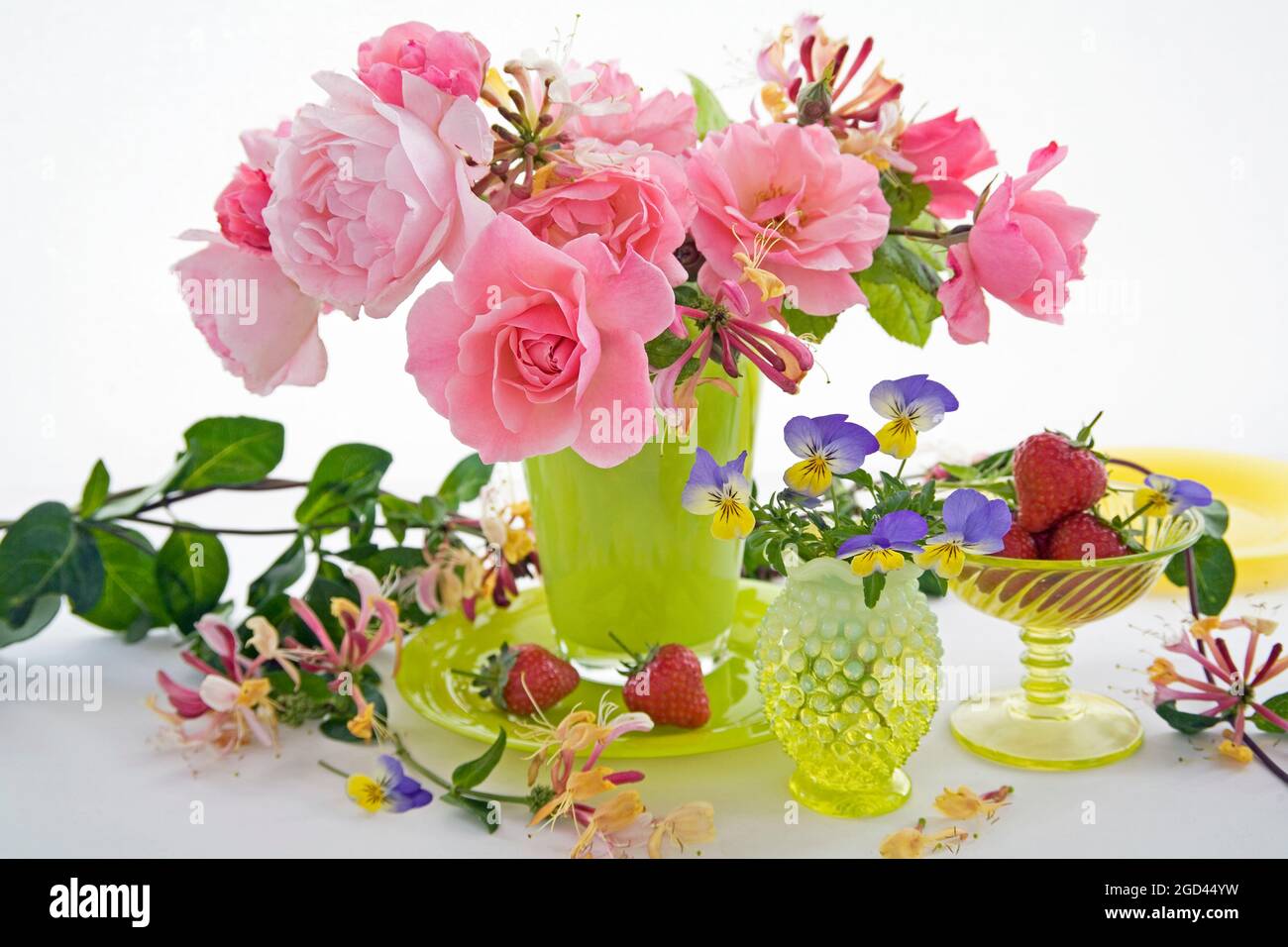 botanique, roses, chèvrefeuille ( lonicera ) et pansies en vases de verre jaune, DROITS-SUPPLÉMENTAIRES-DÉGAGEMENT-INFO-NON-DISPONIBLE Banque D'Images