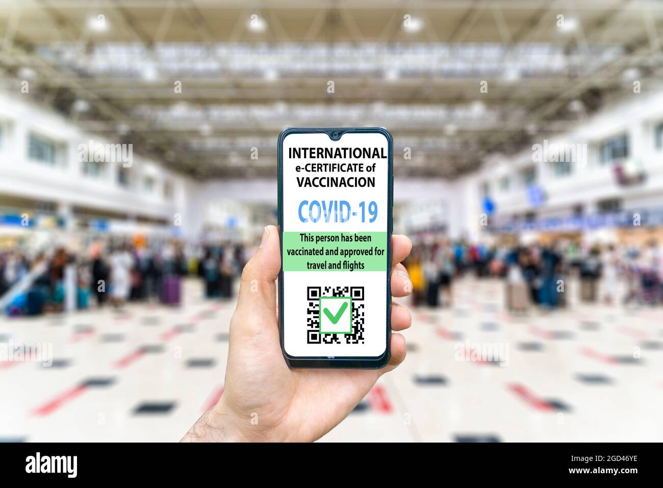 Concept de certificat de vaccination contre le coronavirus ou de passeport vaccinal pour les voyageurs. COVID-19 immunité e-passeport dans l'application mobile pour smartphone pour les voyages internationaux. Main avec un téléphone à l'arrière-plan de la zone de l'aéroport international. Photo de haute qualité Banque D'Images