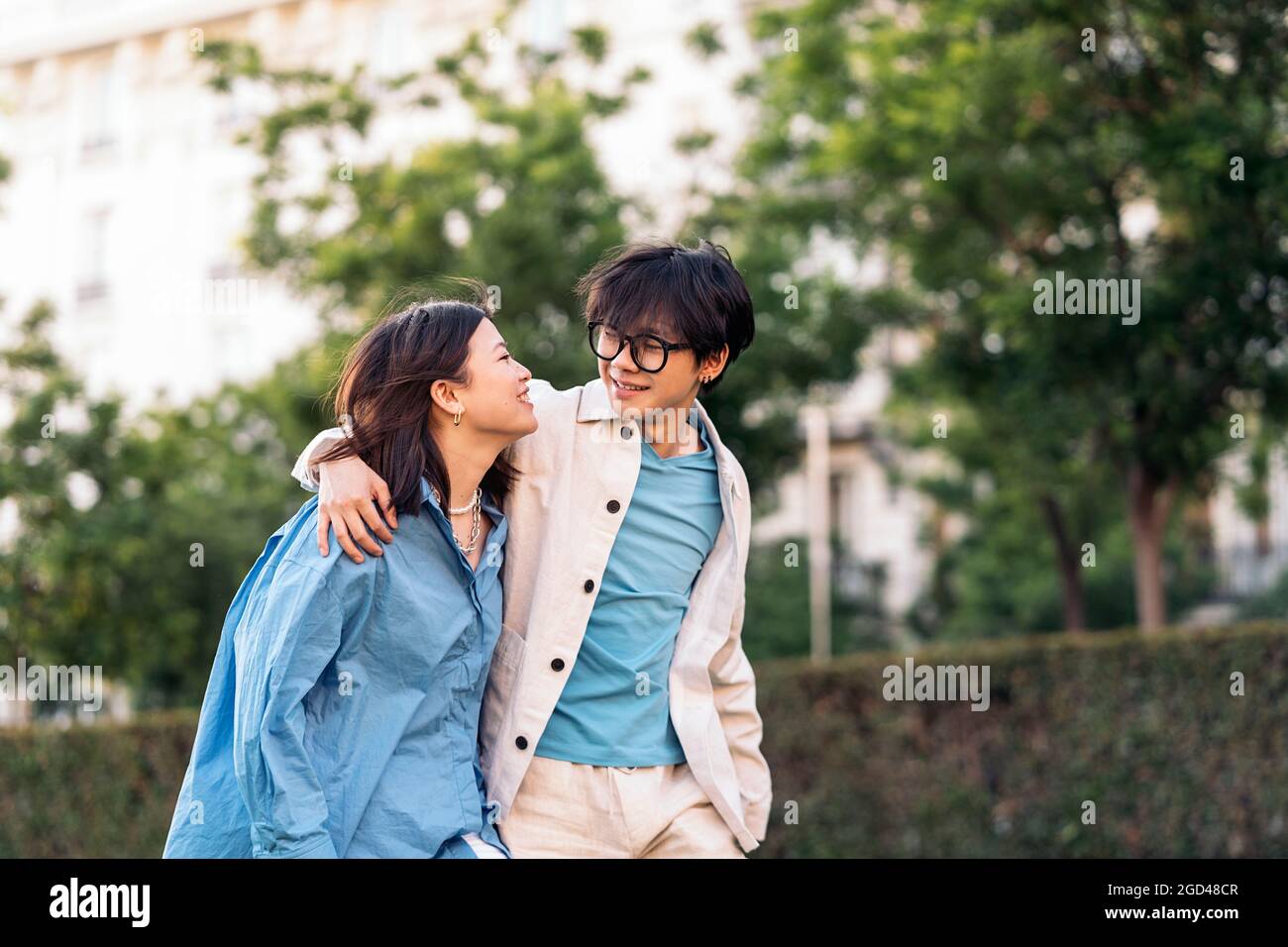 Un adorable couple asiatique souriant et regardant les uns les autres pendant qu'ils marchent dans la ville. Banque D'Images