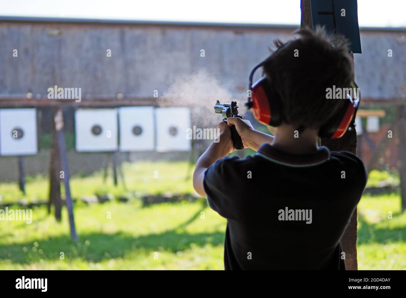 Le jeune garçon se concentre tout en filant à partir d'un revolver à une plage de tournage Banque D'Images