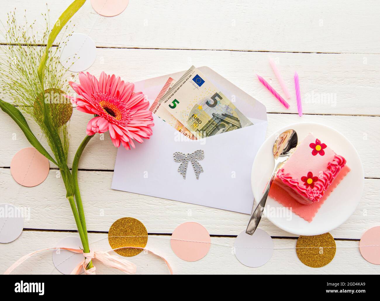 Euro argent comme cadeau d'anniversaire concept. Billets de banque euro à l'intérieur de l'enveloppe, décorés de gâteaux et de fleurs. Banque D'Images