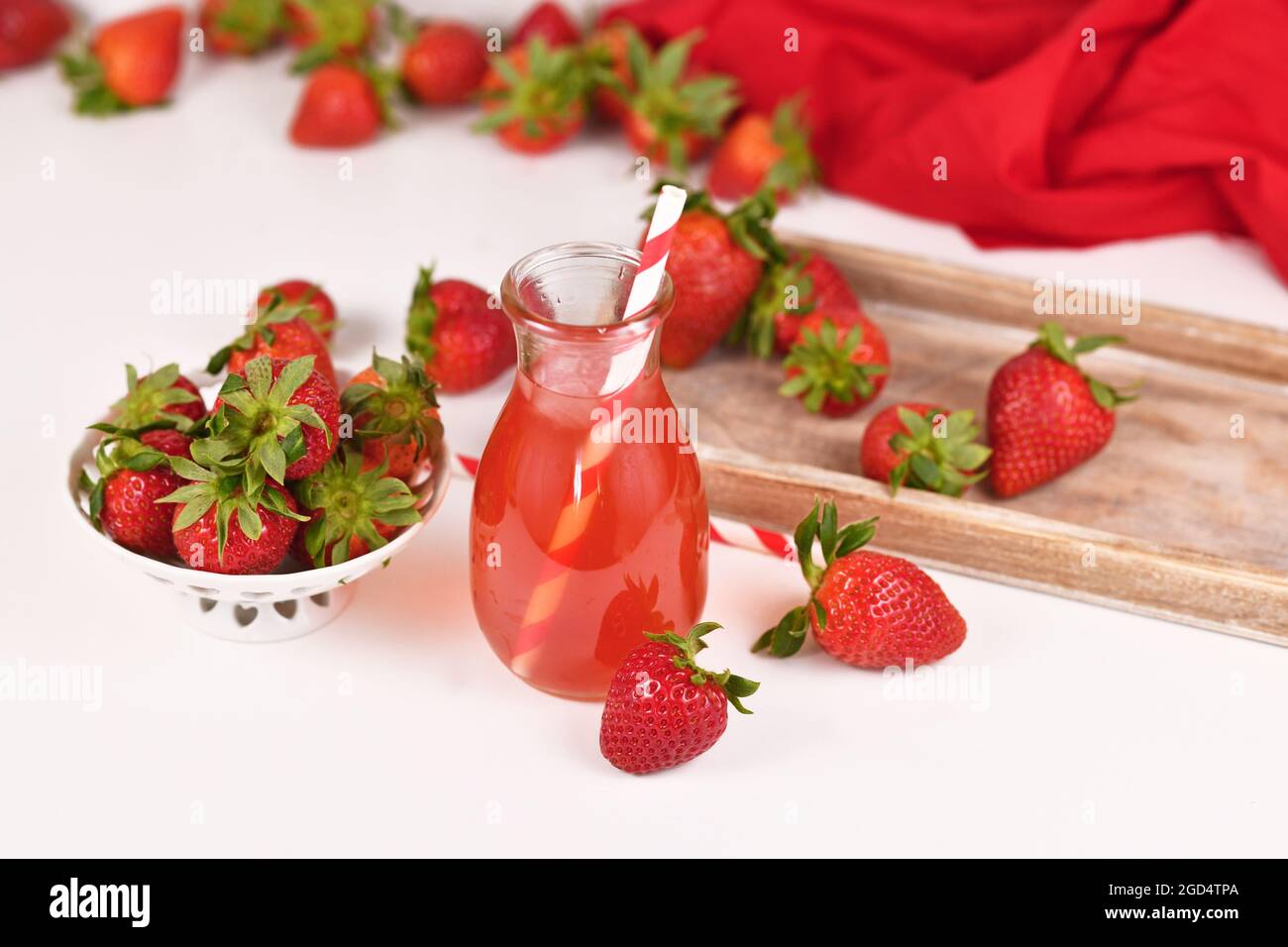Limonade aux fruits à la fraise rouge maison dans un pot entouré de baies Banque D'Images