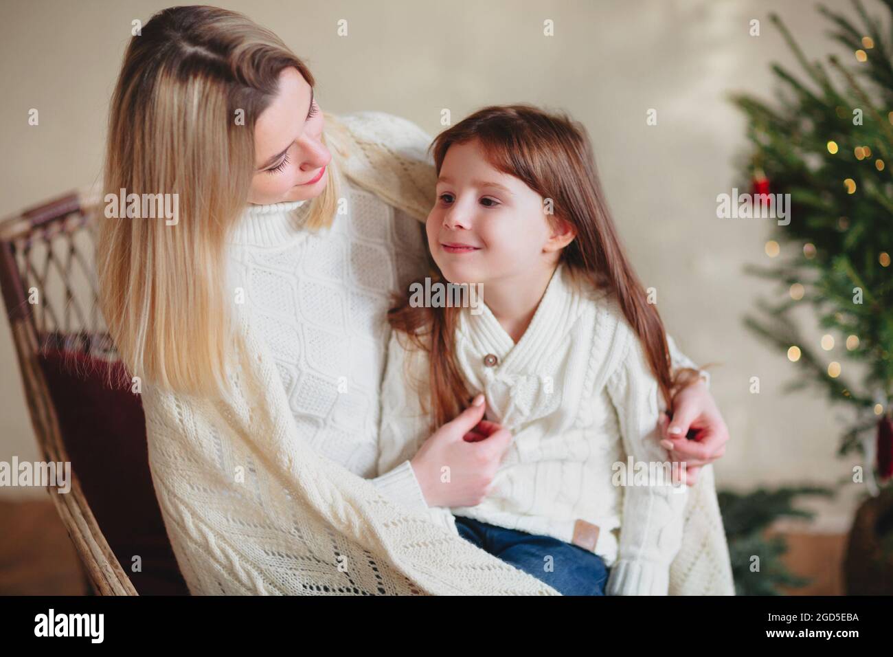Bonne petite fille ludique fille jouant avec la mère positive, passant du temps ensemble pendant les vacances de Noël à la maison, maman et enfant s'amuser Banque D'Images