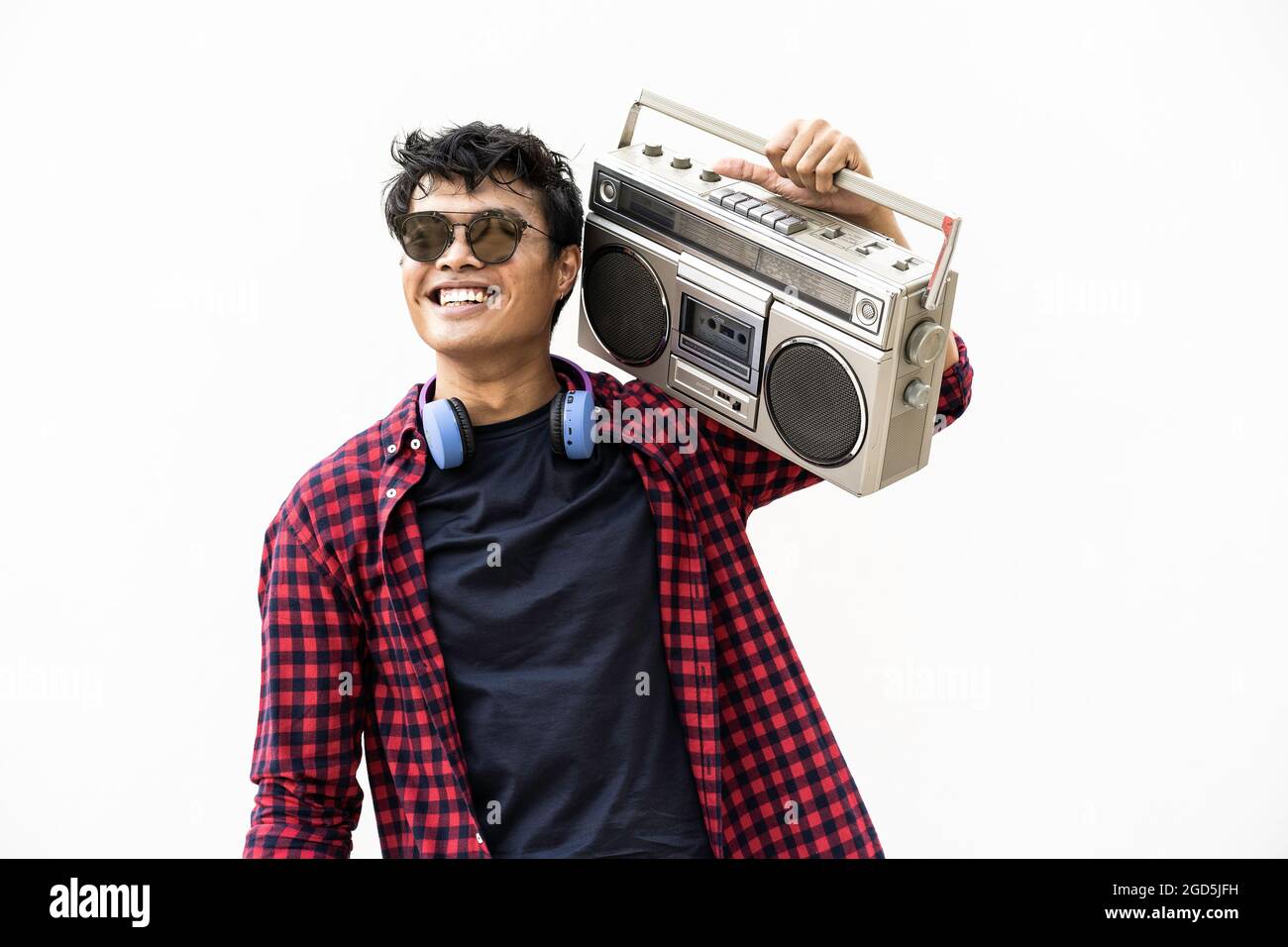 Jeune boxeur asiatique ayant de la musique amusante avec un casque et une boombox vintage pendant les vacances d'été Banque D'Images