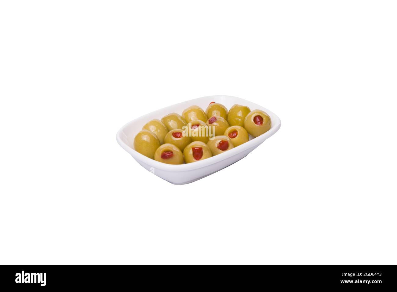 Olives vertes farcies au poivron rouge. Dans un bol blanc sur fond blanc. Banque D'Images