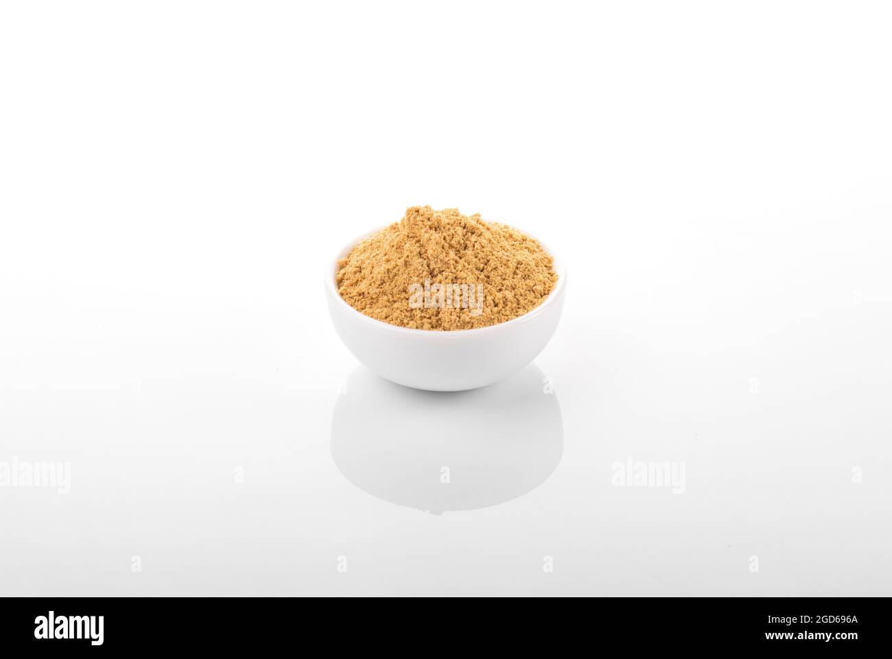 Poudre de gingembre. Poudre de gingembre dans un bol blanc, sur fond blanc. Gingembre, poudre de gingembre. Banque D'Images