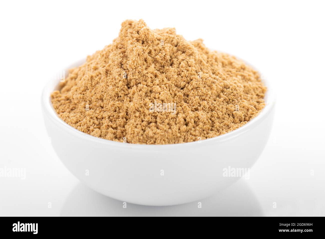 Poudre de gingembre. Poudre de gingembre dans un bol blanc, sur fond blanc. Gingembre, poudre de gingembre. Banque D'Images