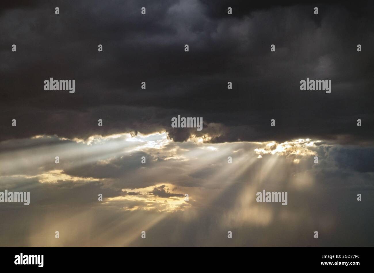 Un rayon de lumière à travers les nuages. Rayons de lumière se brisant à travers les nuages sombres, un ciel dramatique avec des nuages.soleil brillant sous la pluie.espace de copie. Banque D'Images