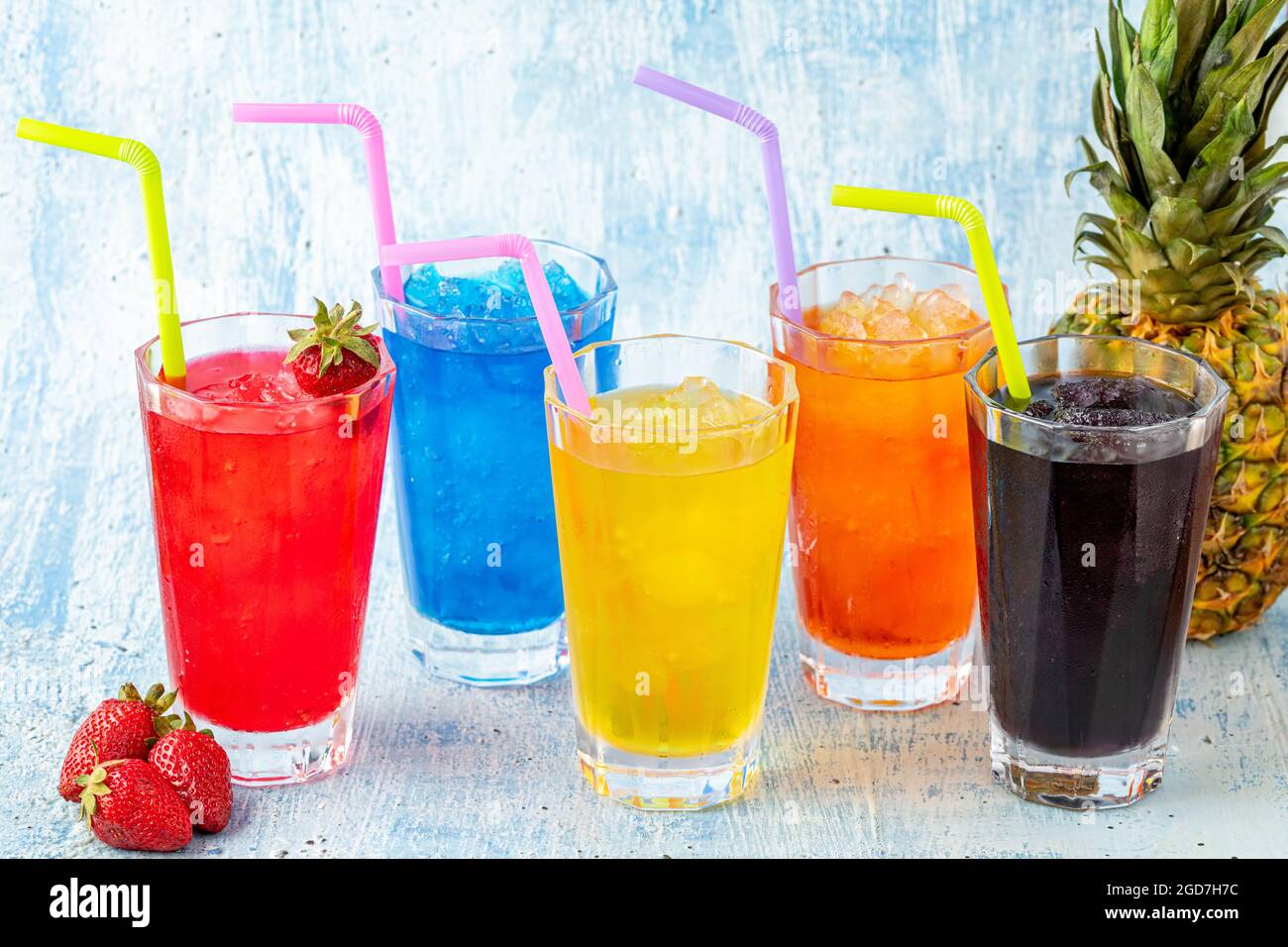 Des grenouzens rafraîchissants dans divers fruits et couleurs sur fond bleu. Banque D'Images