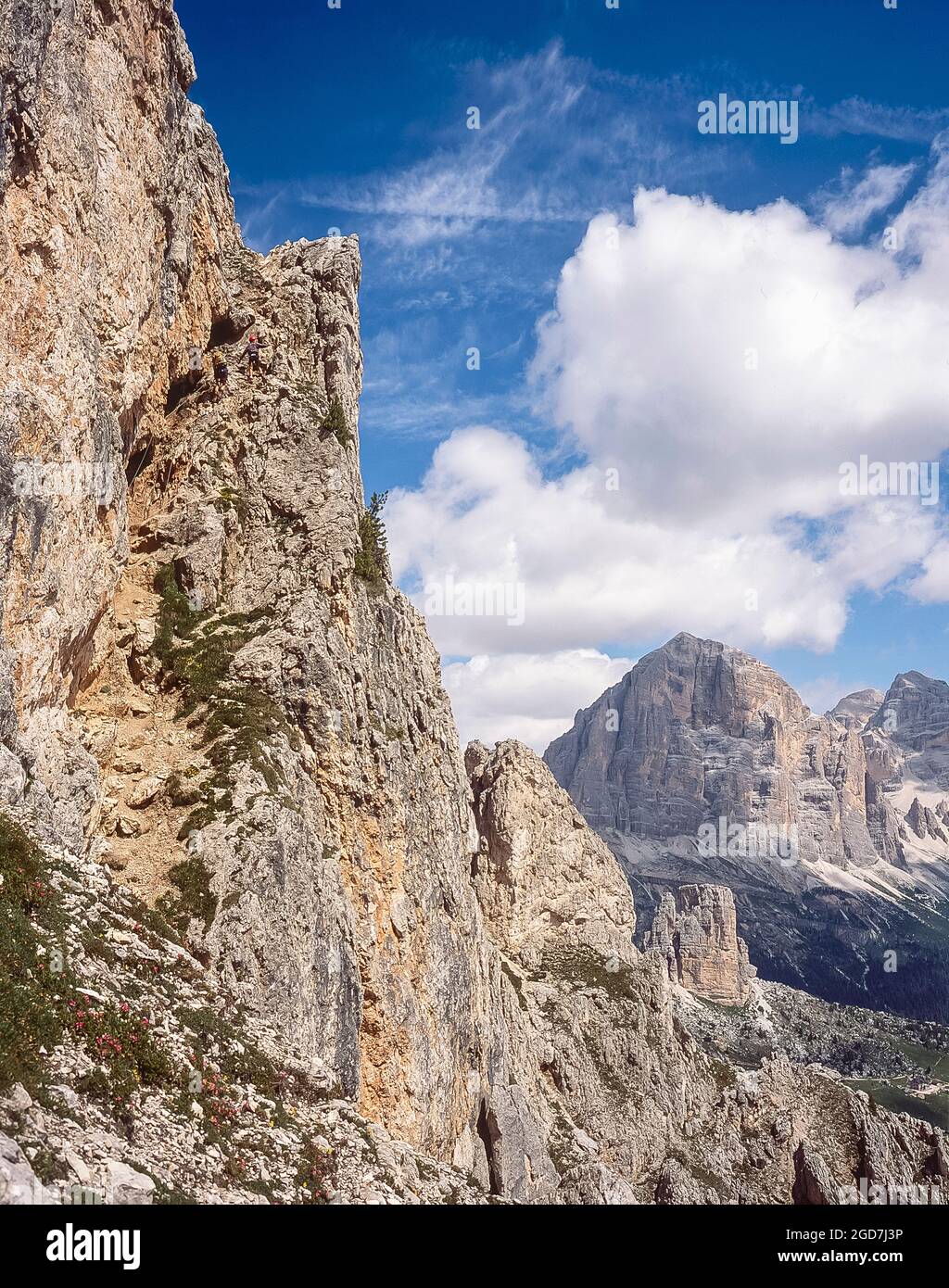 Un groupe de personnes se rend le long du chemin d'escalade protégé via Ferrata jusqu'à la cabane de montagne Rifugio Nuvolau, non loin de la station balnéaire de Cortina d'Ampezzo en regardant vers les rochers de Cinque Torri et le sommet de Tofana di Rozes dans les Dolomites italiennes Banque D'Images