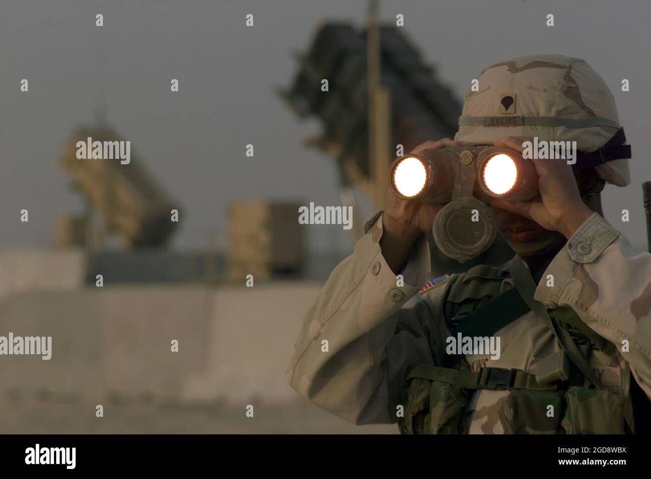 SPÉCIALISTES DE l'armée AMÉRICAINE (USA) quatrième classe (SPC4) Bobby Jenkins, affecté à Delta/Battery, 3e Bataillon-43ème Régiment d'artillerie de défense aérienne (ADA), utilise une paire de jumelles pour balayer le paysage autour de ses missiles Patriot basés à Al Udeid AB, Qatar. (PHOTO DE L'USAF PAR MSGT TERRY L. BLEVINS 030215-F-5712B-003) Banque D'Images