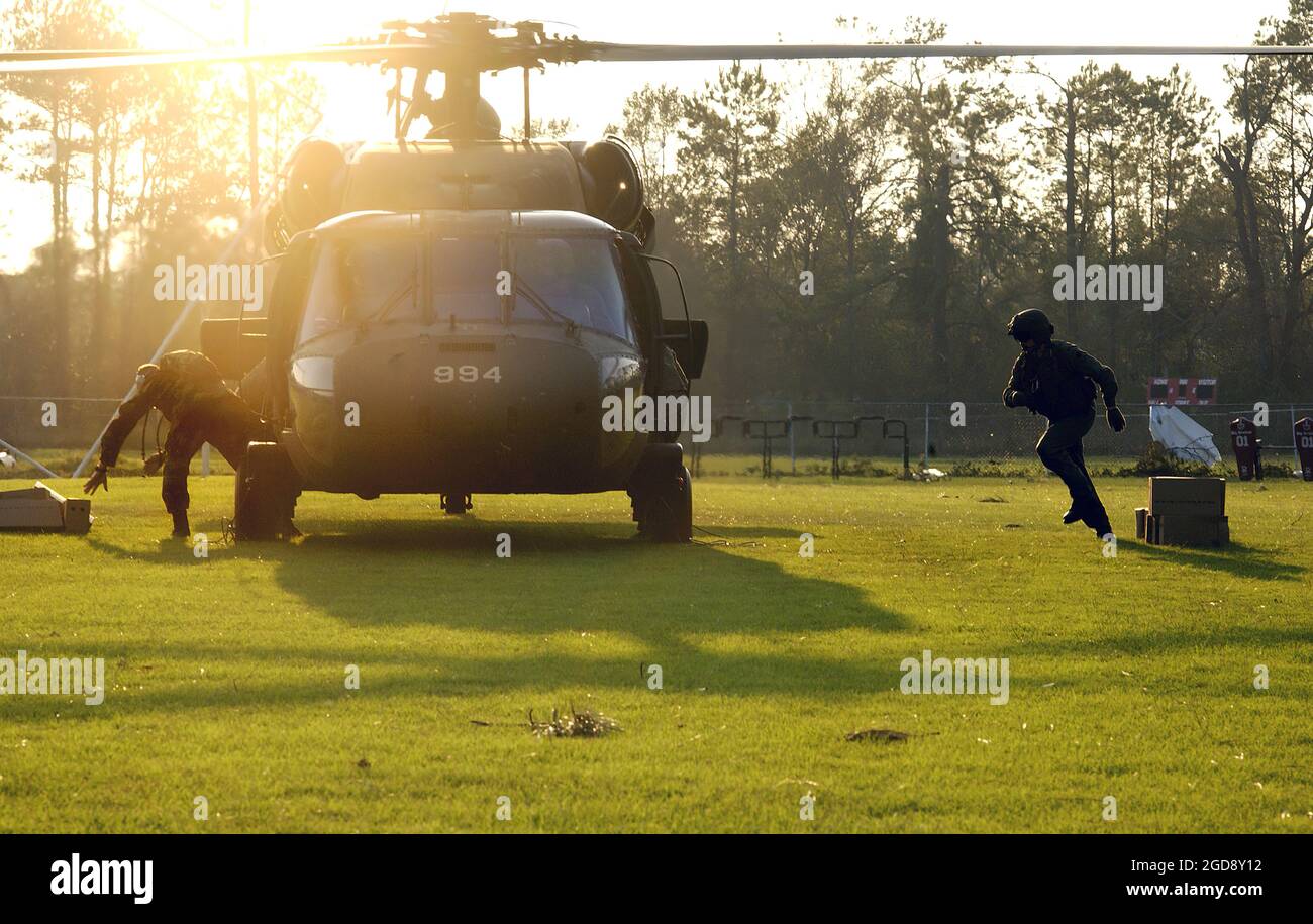 LE personnel DE la Garde nationale DE L'ARMÉE DES ÉTATS-UNIS (États-Unis) déchargent les repas prêts à manger (MRE) d'un hélicoptère américain UH-60A Black Hawk (Blackhawk) à Deweyville, Texas (TX). L'Armée contribue aux opérations d'aide humanitaire de l'ouragan Rita dans le cadre de la Force opérationnelle interarmées (foi) Rita, dirigée par l'Agence fédérale de gestion des urgences (FEMA) en collaboration avec le ministère de la Défense (DoD). (PHOTO USAF PAR SSGT JACOB N. BAILEY 050926-F-5964B-375) Banque D'Images