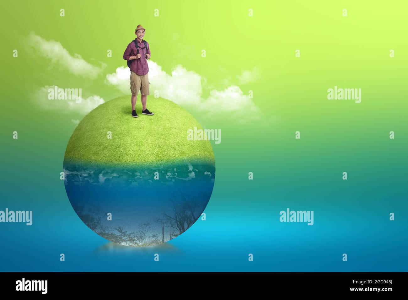 Homme asiatique debout avec un sac à dos sur la prairie avec une vue sous-marine de l'eau bleue. Concept d'environnement Banque D'Images