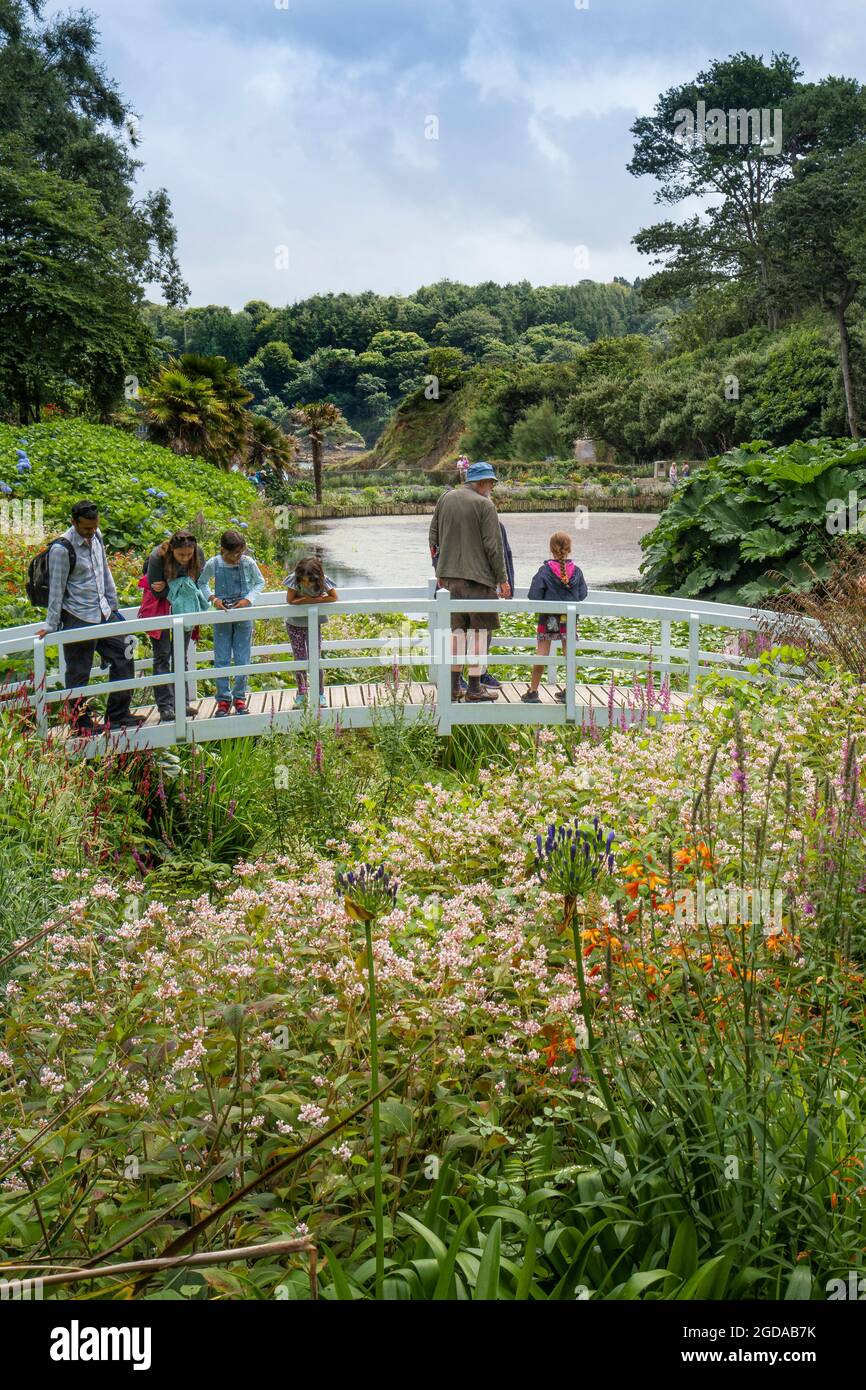 Les visiteurs se trouvant sur la passerelle ornementale au-dessus de l'étang Mallard, dans les jardins subtropicaux luxuriants de Trebah Gardens, dans les Cornouailles. Banque D'Images