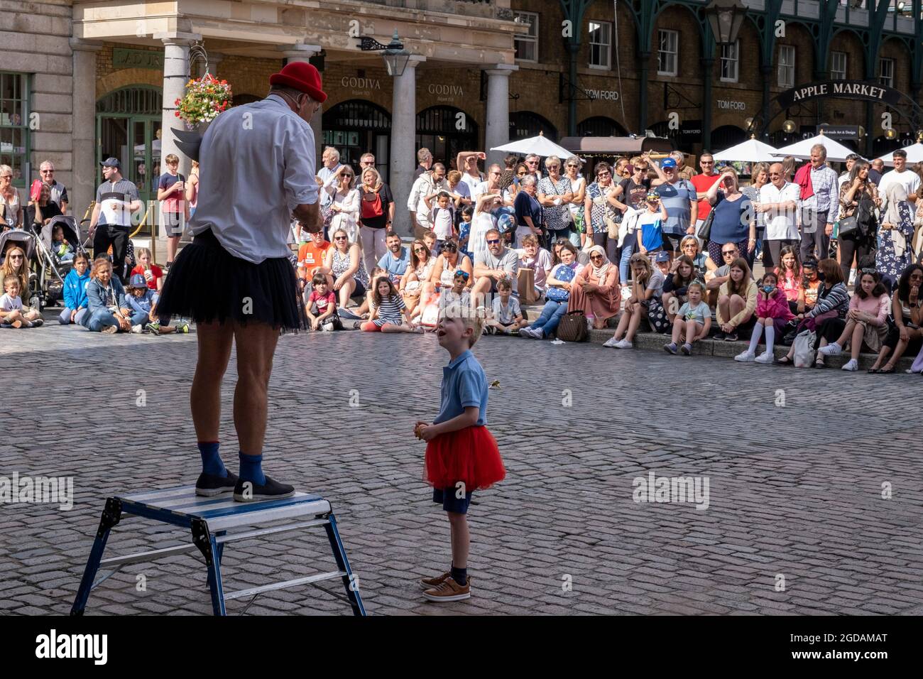 Avec de nombreuses personnes et familles séjournant au Royaume-Uni pour leur séjour d'été pendant les vacances scolaires, un grand nombre de touristes domestiques, Qui aurait normalement voyagé à l'étranger, ont défait sur la capitale pour voir les sites, comme vu ici à Covent Garden où les gens se sont rassemblés pour observer les artistes de rue sur la Plaza le 10 août 2021 à Londres, Royaume-Uni. Après le coronavirus / Covid-19 santé peur des deux dernières années, et avec quelques restrictions de voyage toujours en place, plus de personnes ont choisi une staycation qui est un séjour dans un pays d'origine plutôt que abro Banque D'Images