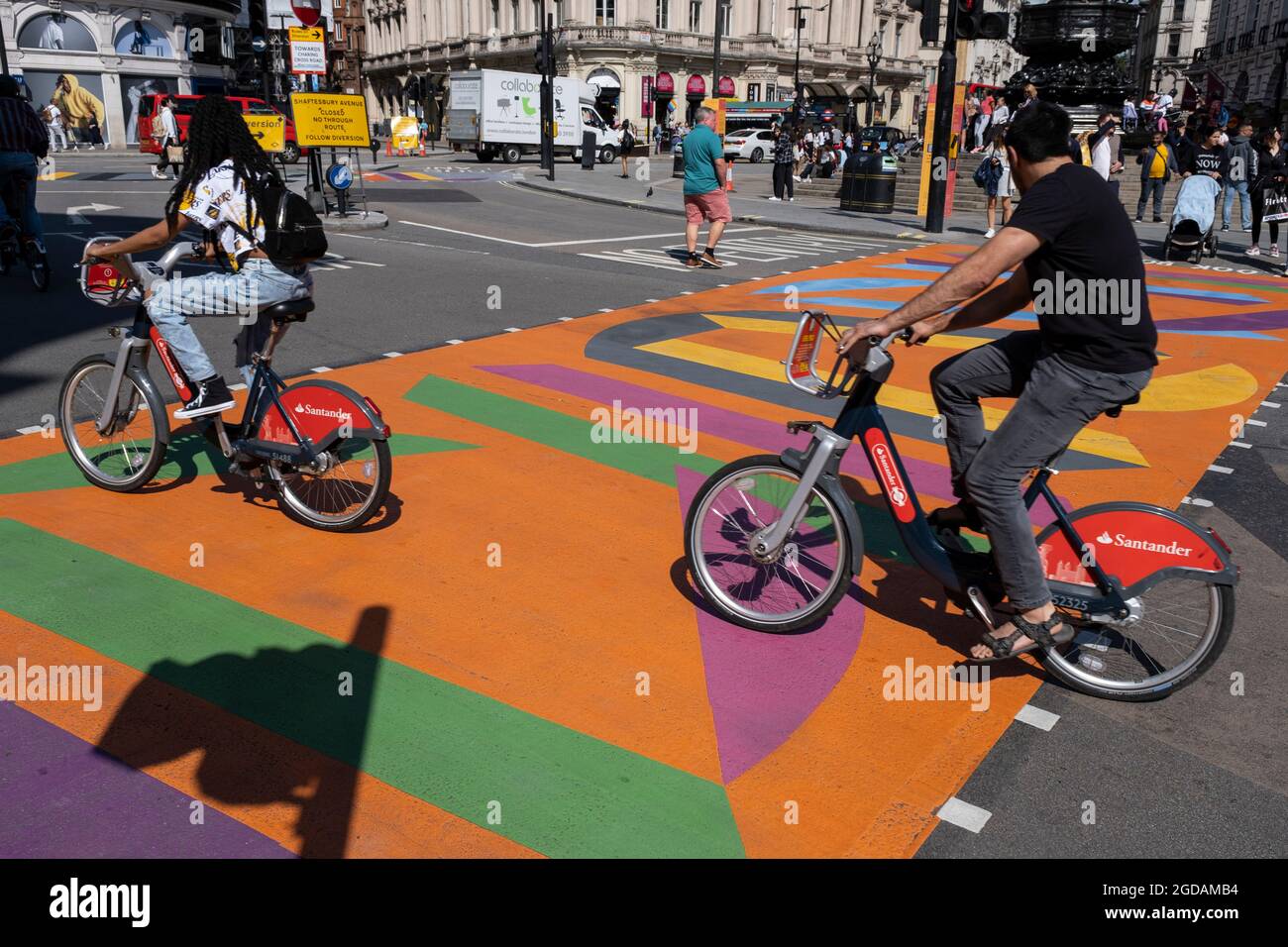 Avec de nombreuses personnes et familles séjournant au Royaume-Uni pour leur séjour d'été pendant les vacances scolaires, un grand nombre de touristes domestiques, Qui aurait normalement voyagé à l'étranger, ont decended dans la capitale pour voir les sites, comme vu ici à Piccadilly Circus, alors que les gens traversent le nouveau graphique et à motifs des passages pour piétons multicolores le 10 août 2021 à Londres, au Royaume-Uni. Après le coronavirus / Covid-19 santé peur des deux dernières années, et avec quelques restrictions de voyage toujours en place, plus de personnes ont choisi une staycation qui est un séjour dans les pays d'origine r Banque D'Images
