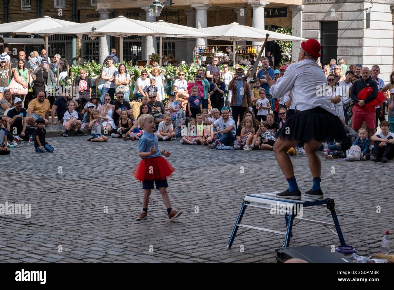 Avec de nombreuses personnes et familles séjournant au Royaume-Uni pour leur séjour d'été pendant les vacances scolaires, un grand nombre de touristes domestiques, Qui aurait normalement voyagé à l'étranger, ont défait sur la capitale pour voir les sites, comme vu ici à Covent Garden où les gens se sont rassemblés pour observer les artistes de rue sur la Plaza le 10 août 2021 à Londres, Royaume-Uni. Après le coronavirus / Covid-19 santé peur des deux dernières années, et avec quelques restrictions de voyage toujours en place, plus de personnes ont choisi une staycation qui est un séjour dans un pays d'origine plutôt que abro Banque D'Images