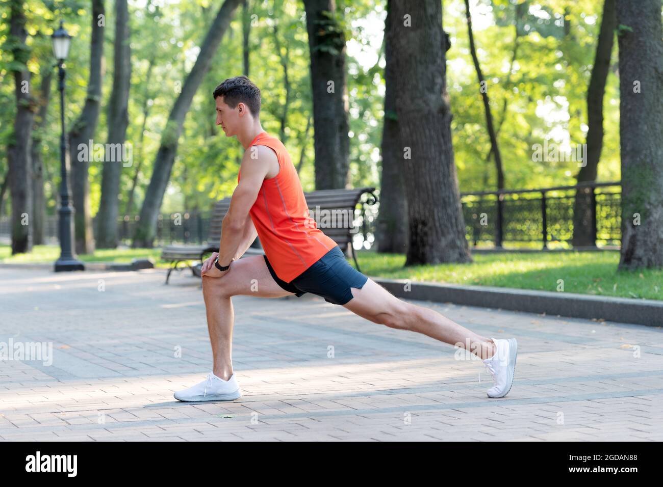 Homme sportif en position de fente. Étirez la jambe après l'entraînement. Routine d'étirement Banque D'Images