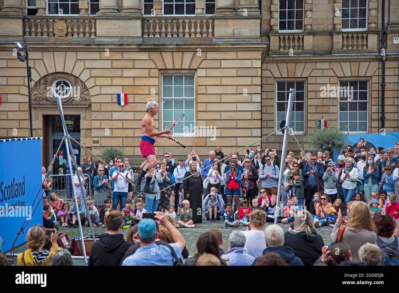 Royal Mile, Édimbourg, Écosse, Royaume-Uni. 12 août 2021. Festival Fringe d'Édimbourg, le septième jour de l'événement sur la capitale High Street. Temps gréeux et nuageux avec une température de 18 degrés pour les statues humaines et les artistes de rue attirant des foules à leurs emplacements. Photo : Kwabana Lindsay divertit un grand public sur Parlnet Square. Crédit : Arch White/Alamy Live News Banque D'Images