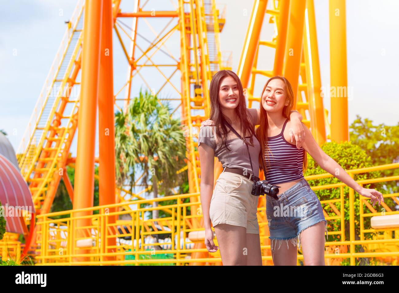 les femmes sourires heureux voyage dans le parc d'attractions amusement profiter portrait souriant avec des amis dans les parcs à thème saison d'été en arrière-plan extérieur. Banque D'Images