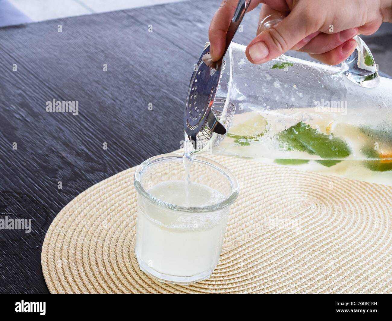 la limonade maison coule de la verseuse en verre avec un filtre en verre Banque D'Images