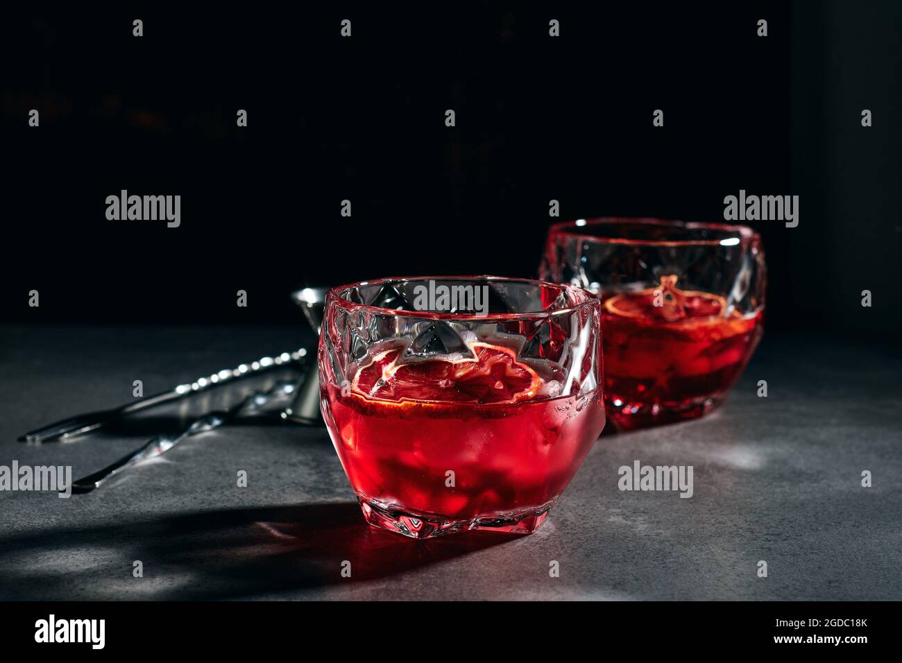 Cocktail Negroni à l'orange rouge sur fond noir. Banque D'Images