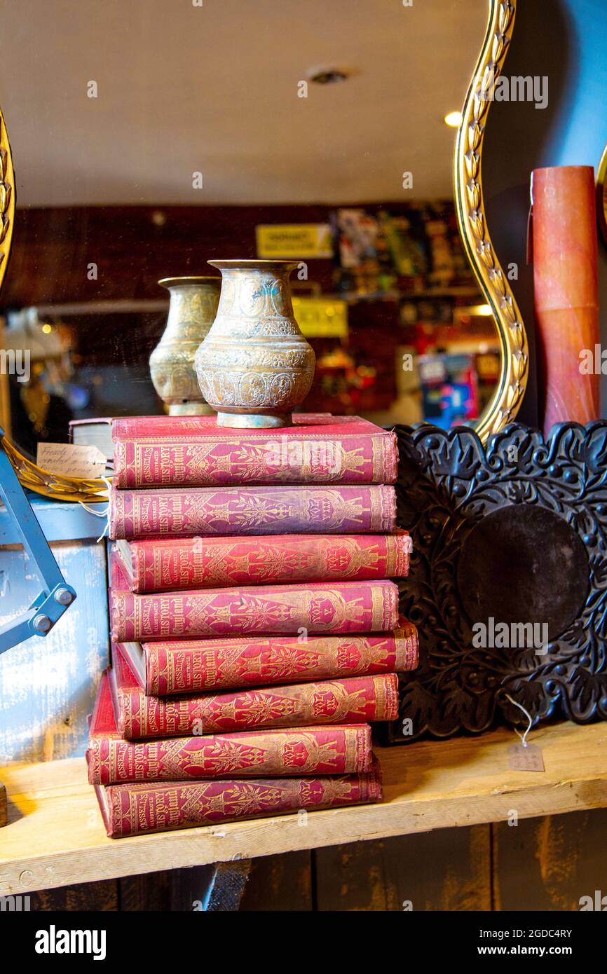 Exposition de livres d'époque empilés et vase antique à la boutique Maltings antiques de Sawbridgeworth, Royaume-Uni Banque D'Images