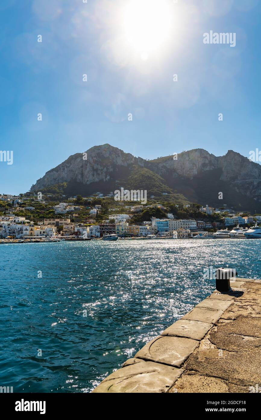 Capri, Italie - août 24 2020 : petit port de la ville au bord de l'île avec les montagnes de Monte Solaro au-dessus de lui par beau temps Banque D'Images