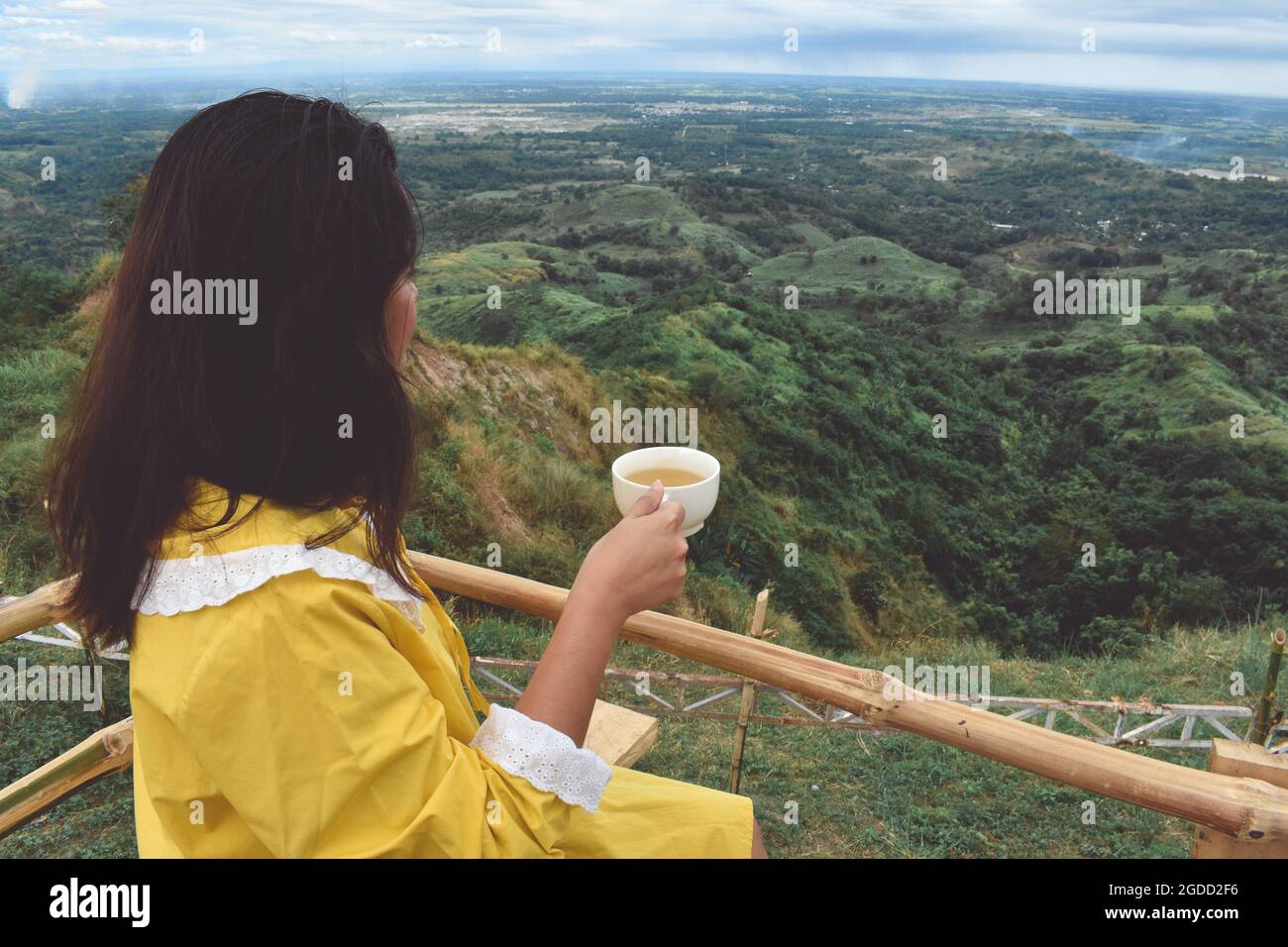 Femme buvant du thé contre les chaînes de montagnes Banque D'Images