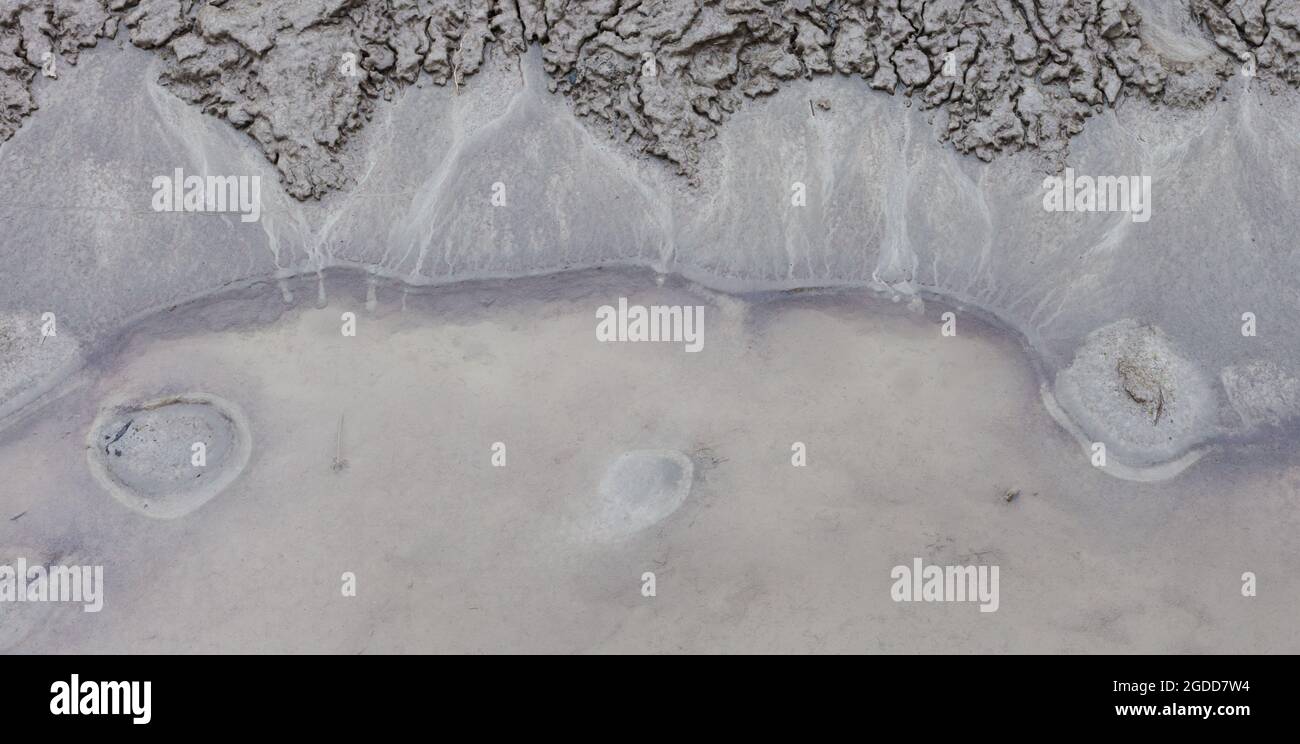 Caractéristiques géographiques à micro-échelle dans le limon après une inondation de rivière. Le paysage ressemble à des images satellites, avec des canyons, des vallées fluviales, des deltas, des gorges. Banque D'Images