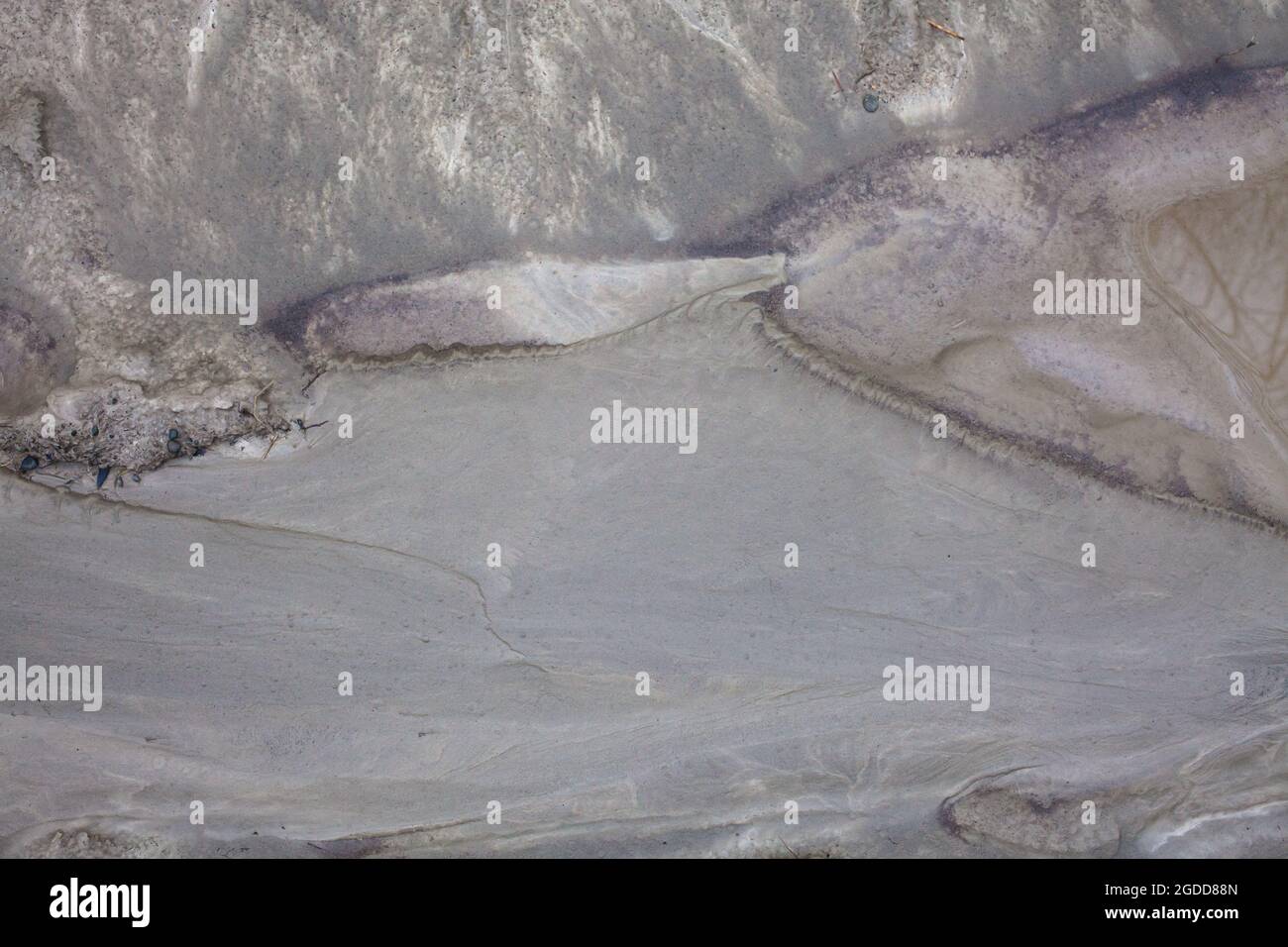 Caractéristiques géographiques à micro-échelle dans le limon après une inondation de rivière. Le paysage ressemble à des images satellites, avec des canyons, des vallées fluviales, des deltas, des gorges. Banque D'Images